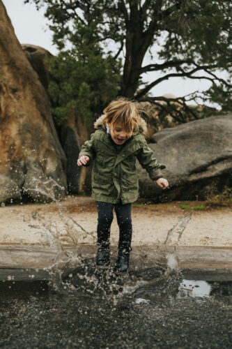 girl jumping in puddle